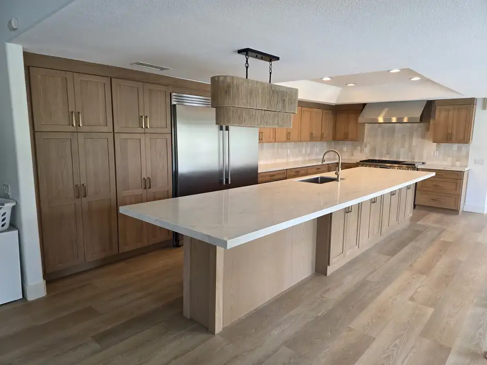 Kitchen remodeling Orange County project by Better Remodels: light oak cabinets, a long white island and a woven pendant light