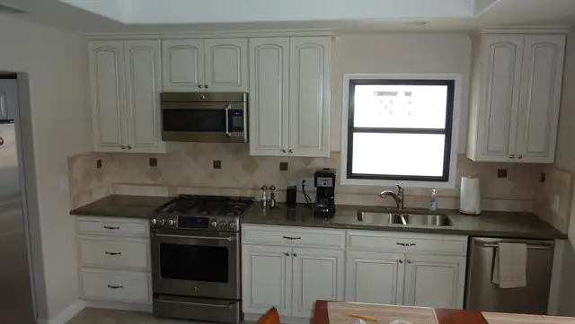 Huntington Beach kitchen remodel with white raised-panel cabinets, tile backsplash and stainless appliances